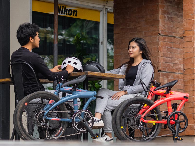 A couple enjoy cafe time after a short journey with their folding bikes A couple enjoy cafe time after a short journey with their folding bikes
