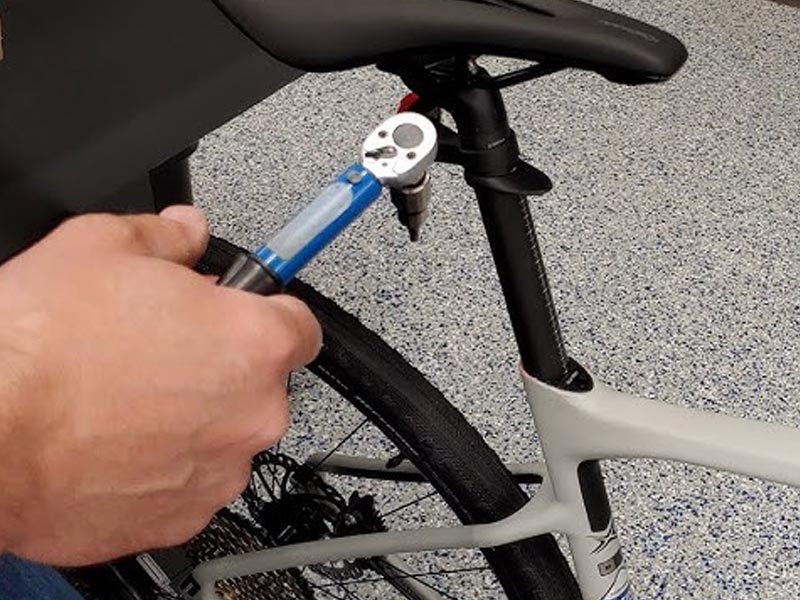 A cyclist adjusting his road bike’s Seatpost A cyclist adjusting his road bike’s Seatpost