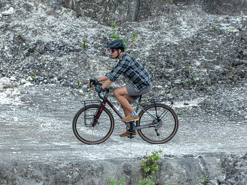A cyclist leisurely riding with a gravel bike A cyclist leisurely riding with a gravel bike