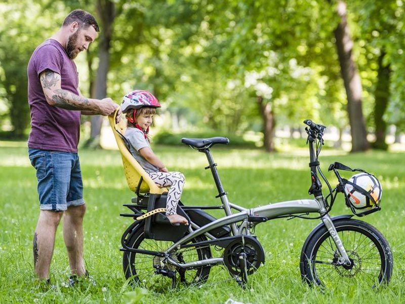 Seorang anak sedang duduk di child seat sepeda lipat Seorang anak sedang duduk di child seat sepeda lipat