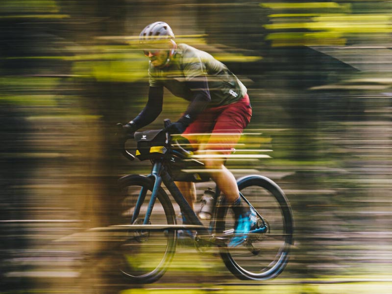 Atlet berpacu di lintasan dengan cepat menggunakan sepeda gravel Atlet berpacu di lintasan dengan cepat menggunakan sepeda gravel