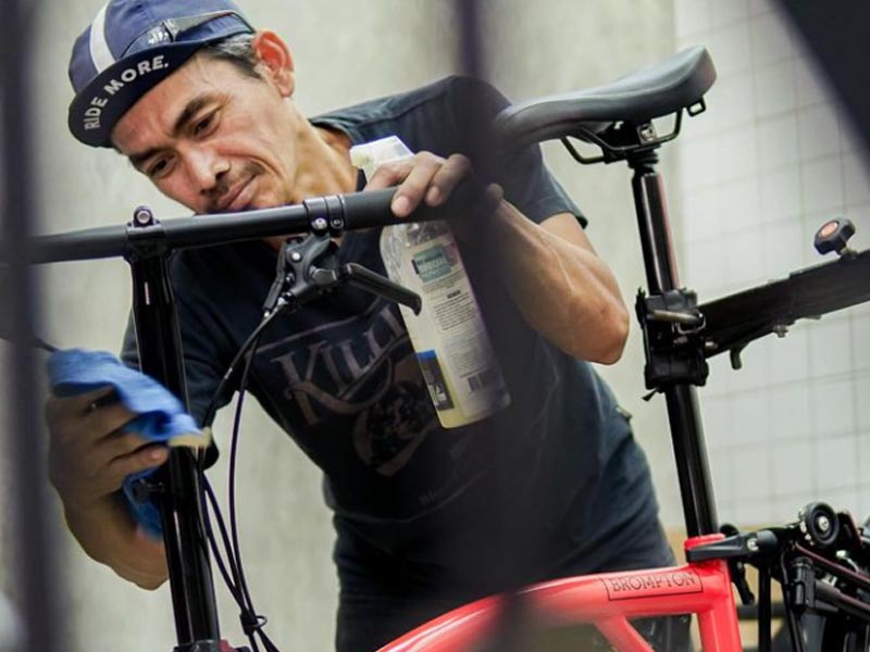 Foldable bike owner cleans his bike to keep it shiny and well-maintained Foldable bike owner cleans his bike to keep it shiny and well-maintained
