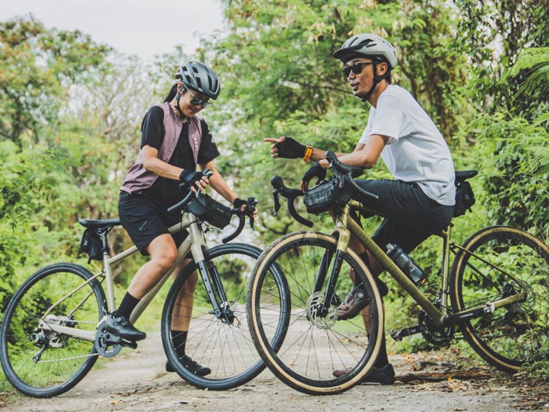 A couple take a break after a half tour riding with their road bike A couple take a break after a half tour riding with their road bike