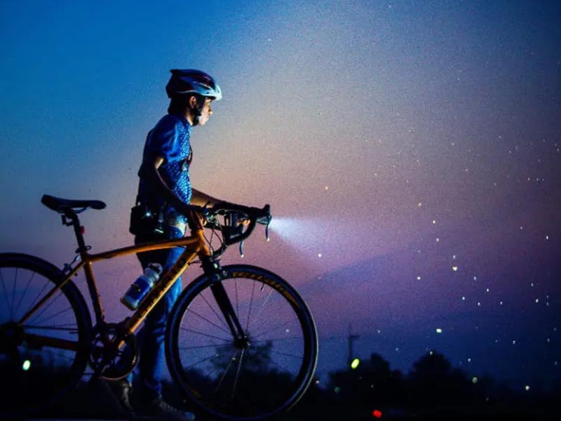 The road bike’s front lamps shine brightly during low-light conditions in the evening The road bike’s front lamps shine brightly during low-light conditions in the evening