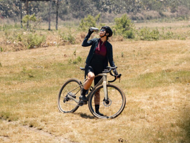 A road biker keeps hydrated by drinking water A road biker keeps hydrated by drinking water