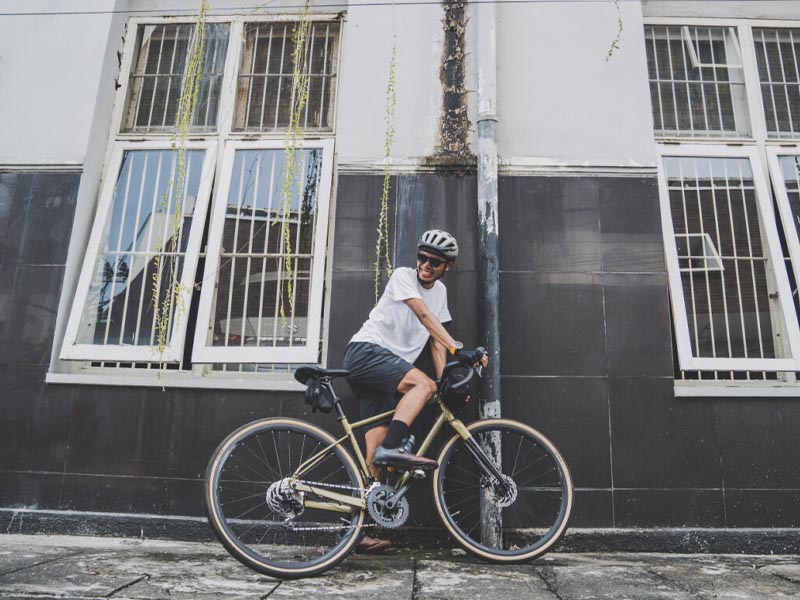 A rider smiles happily after a satisfying ride in the city with his gravel bike A rider smiles happily after a satisfying ride in the city with his gravel bike