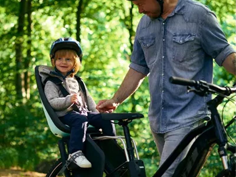 A young girl sits comfortably in the rear child seat A young girl sits comfortably in the rear child seat
