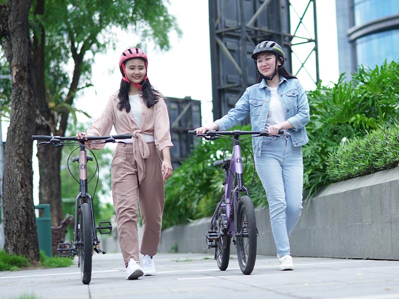 Two riders walking together with their gili velo after a city ride Two riders walking together with their gili velo after a city ride