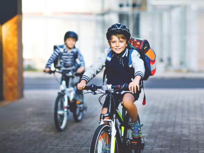 A young boy ride his kids MTB bike to go to school A young boy ride his kids MTB bike to go to school