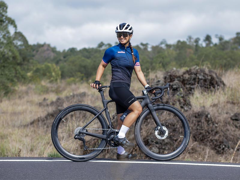 A woman road biker smiles happily in the middle of her riding journey A woman road biker smiles happily in the middle of her riding journey