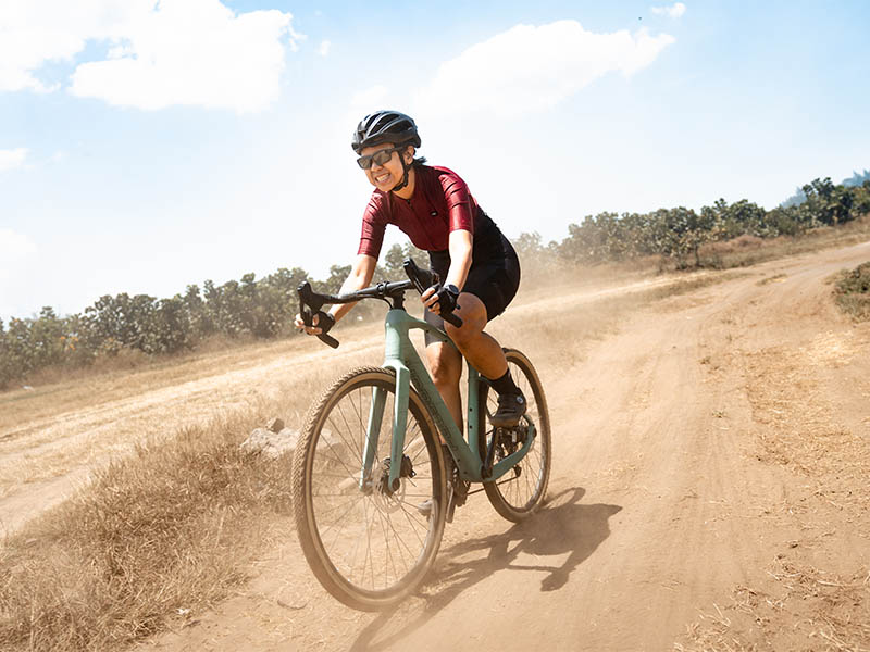 Female cyclist perform on the gravel track Female cyclist perform on the gravel track