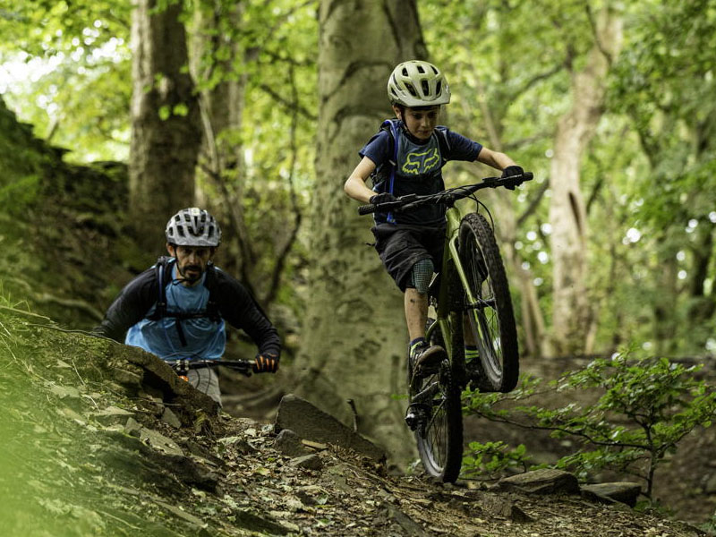 Seorang anak latihan bersepeda gunung bersama orang tuanya Seorang anak latihan bersepeda gunung bersama orang tuanya