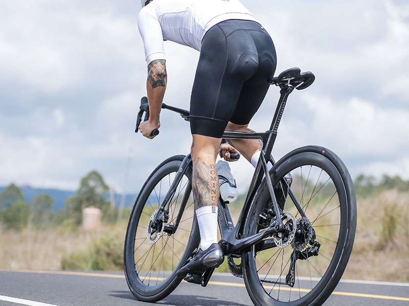 Cyclist mengayuh pedal sepeda balap dengan sepatu dan kaos kakinya Cyclist mengayuh pedal sepeda balap dengan sepatu dan kaos kakinya