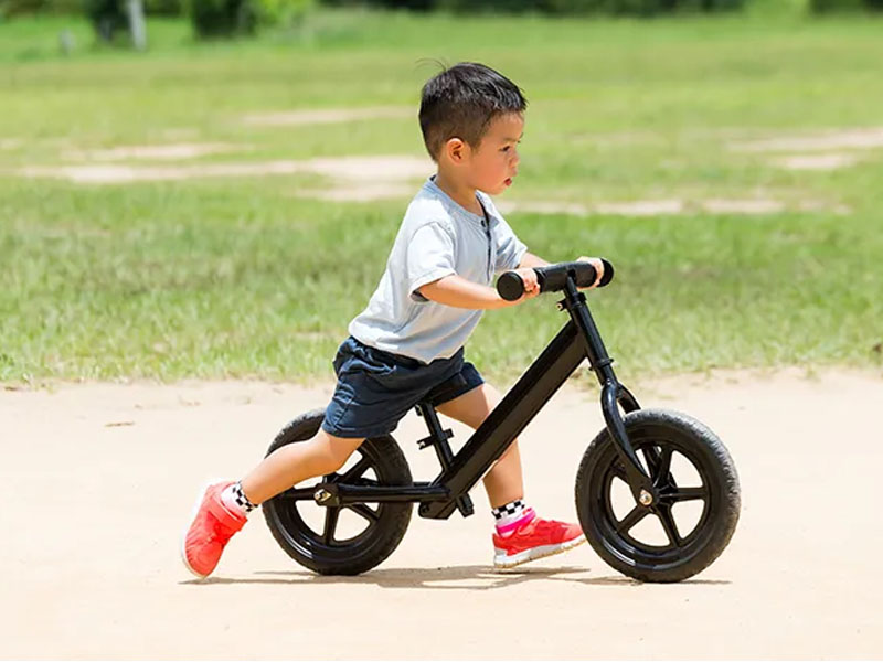 Seorang Anak Menggunakan Balance Bike untuk Melatih Koordinasi Seorang Anak Menggunakan Balance Bike untuk Melatih Koordinasi