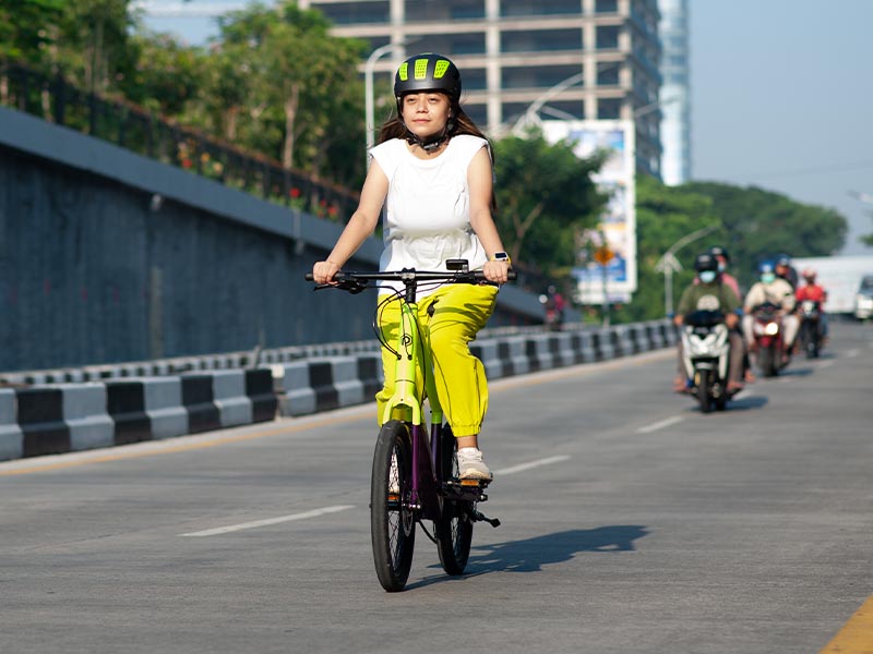 Cyclist sedang komuter di dalam kota dengan sepeda elektrik mini velo Cyclist sedang komuter di dalam kota dengan sepeda elektrik mini velo