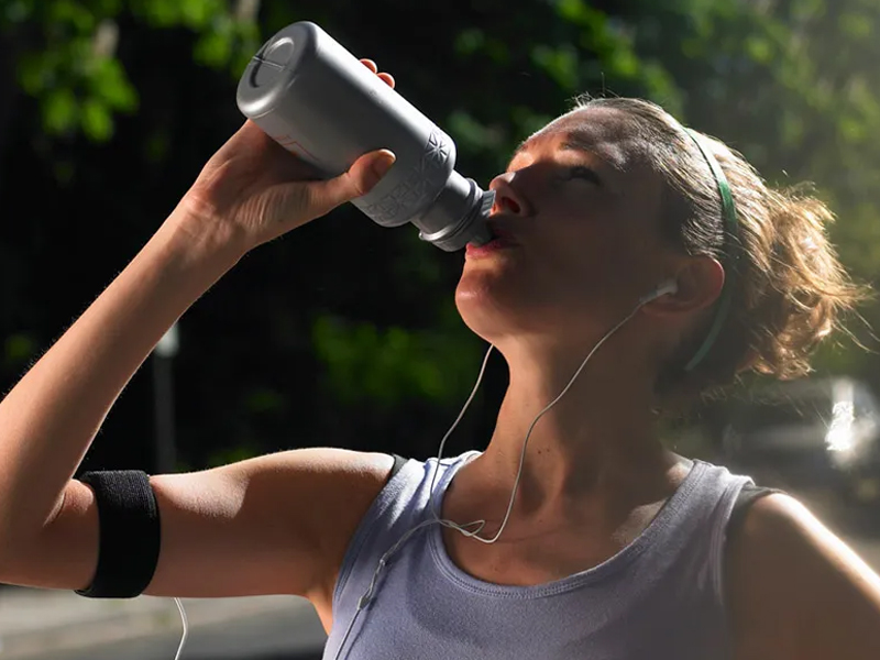 Seorang pelari meminum air dari botol air setelah berlari Seorang pelari meminum air dari botol air setelah berlari