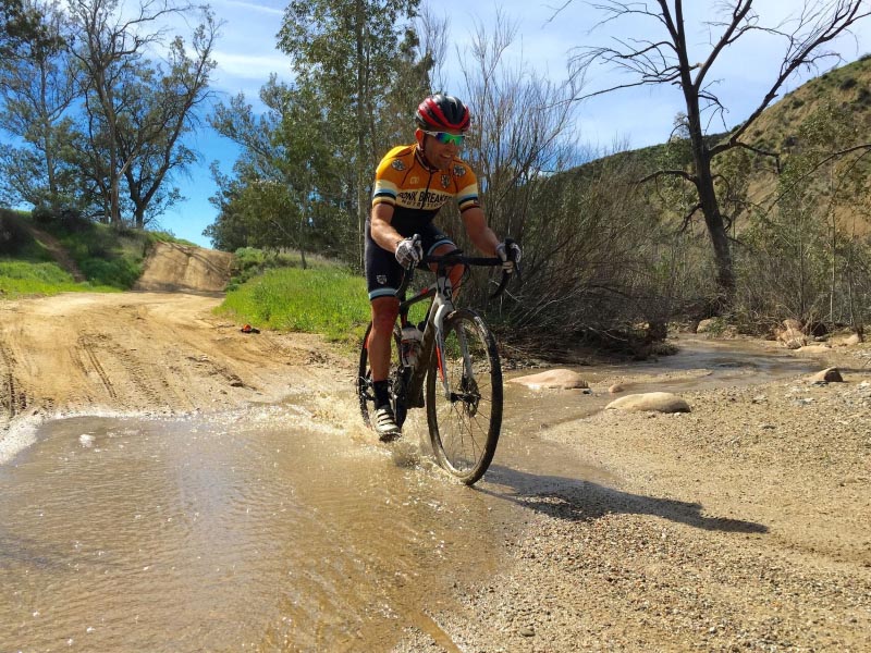 Gravel cyclists confidently tackle the wet and rocky surface Gravel cyclists confidently tackle the wet and rocky surface