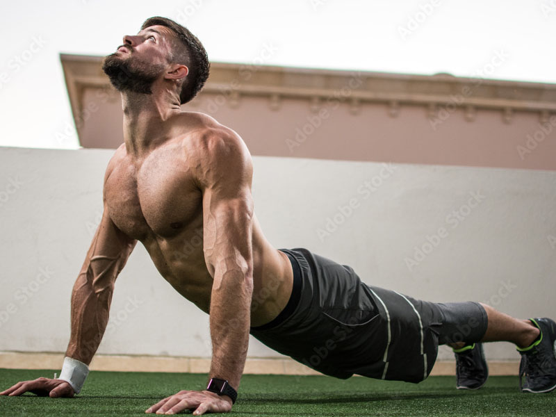 Seorang pria melakukan cobra pose untuk latihan fleksibilitas Seorang pria melakukan cobra pose untuk latihan fleksibilitas