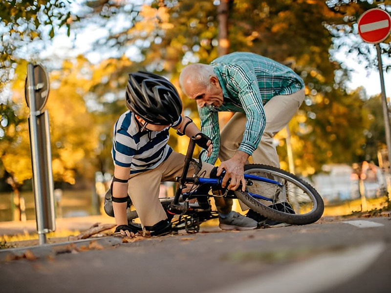 Seorang anak jatuh dari sepeda dengan memakai helm Seorang anak jatuh dari sepeda dengan memakai helm