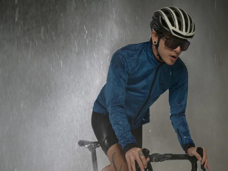 Cyclist memakai jaket anti air sebelum naik sepeda gunung di musim hujan Cyclist memakai jaket anti air sebelum naik sepeda gunung di musim hujan
