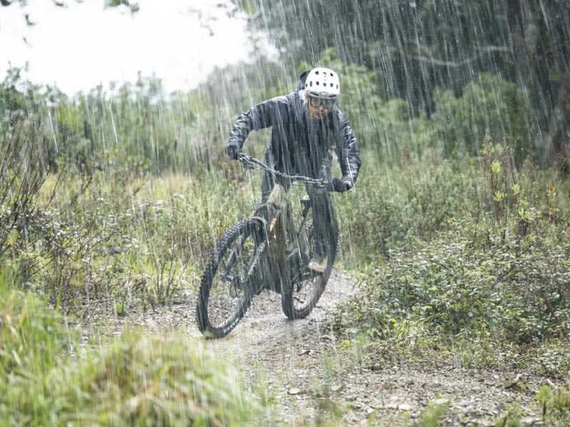 Cyclist menggunakan sepeda gunung saat hujan deras Cyclist menggunakan sepeda gunung saat hujan deras