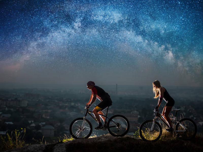A couple cycling together under the stars A couple cycling together under the stars