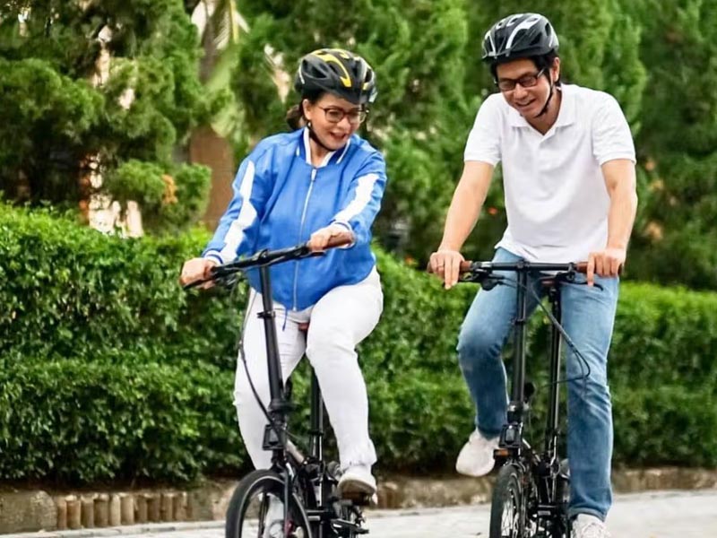 A couple ride folding bikes together A couple ride folding bikes together