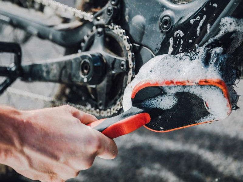 Seorang pria mencuci sepeda listrik dengan hati-hati Seorang pria mencuci sepeda listrik dengan hati-hati