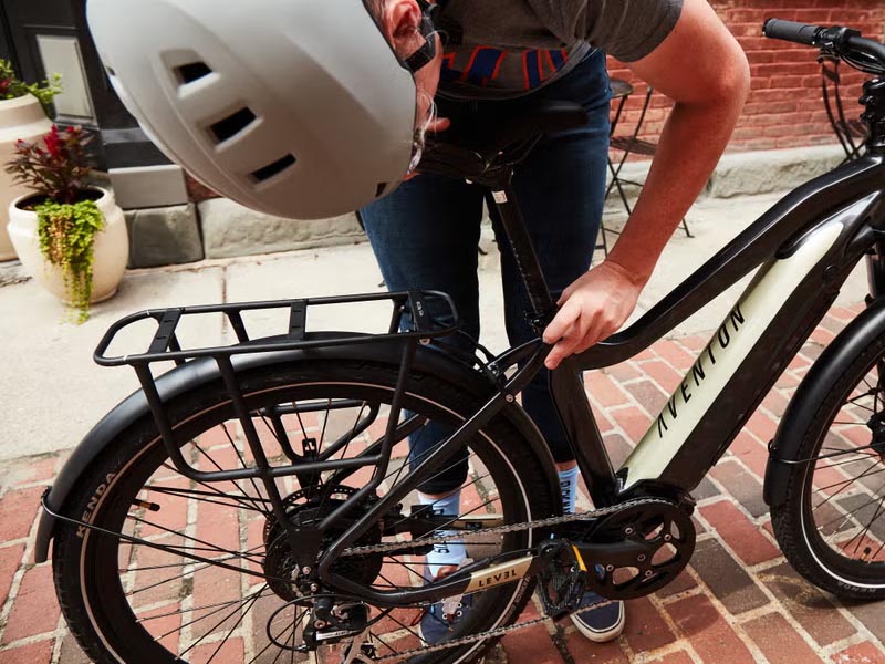 Seorang cyclist sedang melakukan perawatan rutin sepeda listriknya Seorang cyclist sedang melakukan perawatan rutin sepeda listriknya