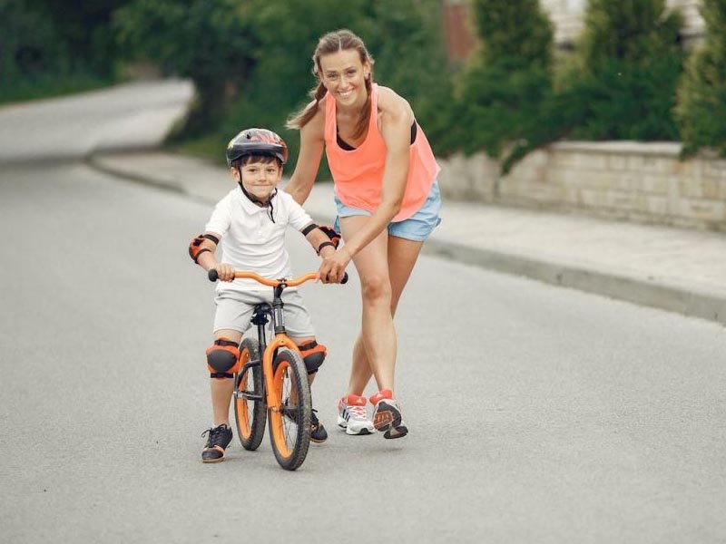 Orang tua mendampingi anaknya belajar sepeda Orang tua mendampingi anaknya belajar sepeda