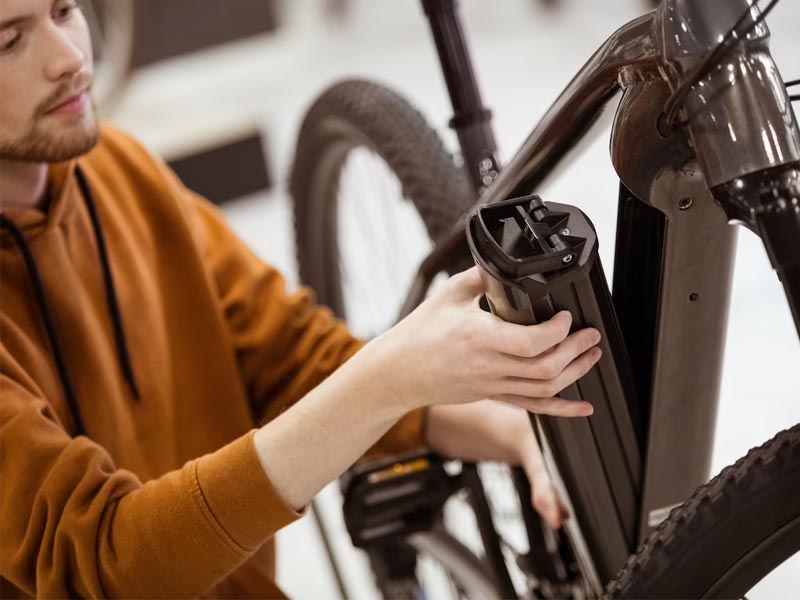 Cyclist maintaining electric bike Cyclist maintaining electric bike