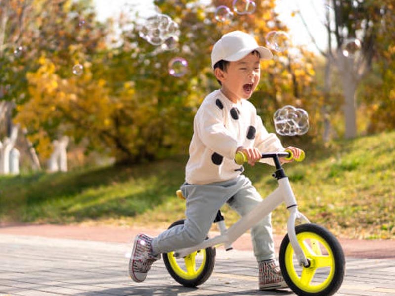 A boy happily ride his push bike A boy happily ride his push bike