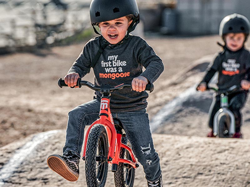 A kid is happy to ride a push bike A kid is happy to ride a push bike