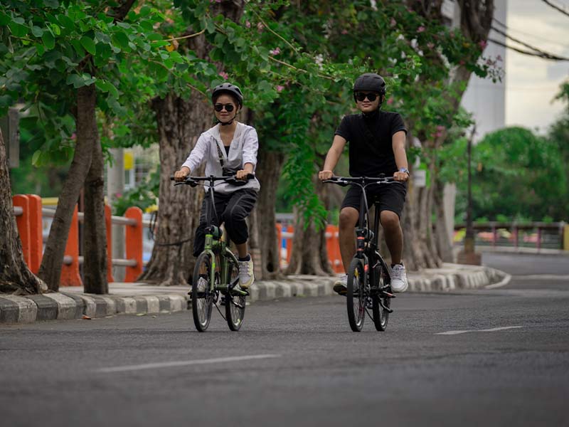 A couple enjoy their morning ride with foldable bikes A couple enjoy their morning ride with foldable bikes
