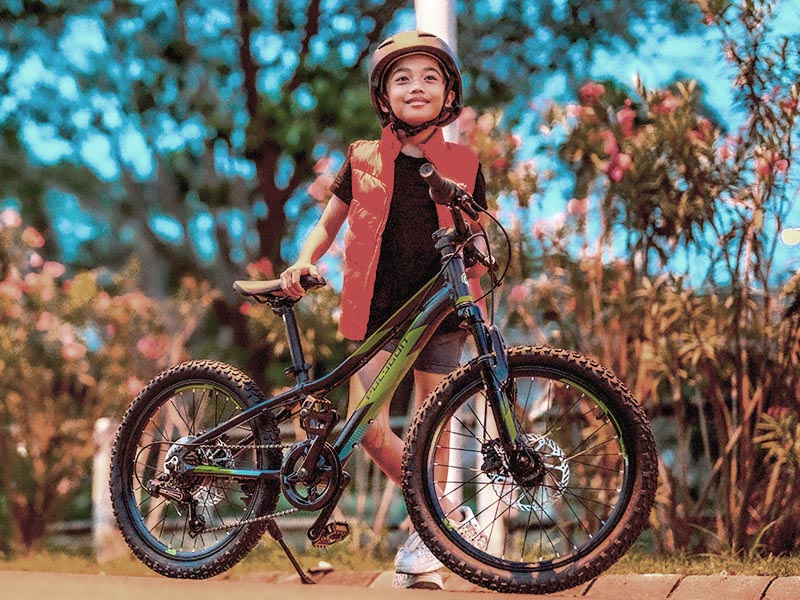 A boy brings his Polygon kids bike to the park A boy brings his Polygon kids bike to the park