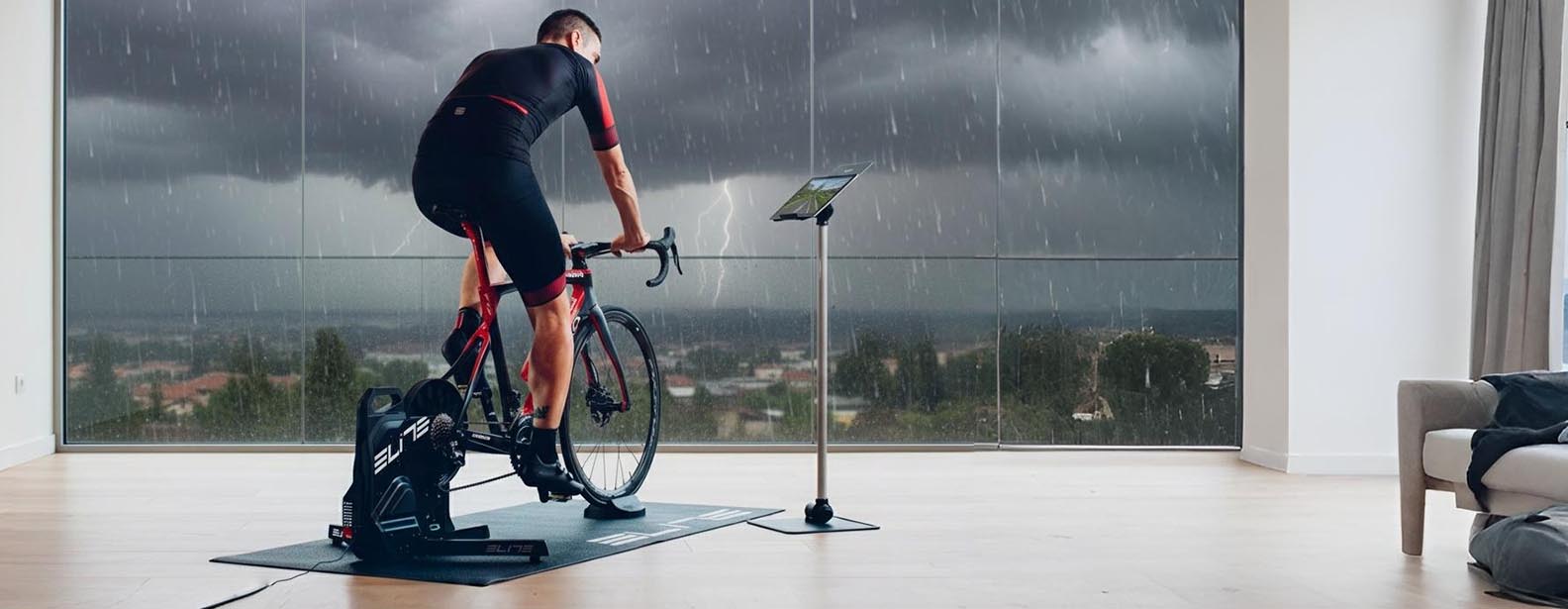 An indoor trainer is being used by a cyclist when it’s raining outside An indoor trainer is being used by a cyclist when it’s raining outside